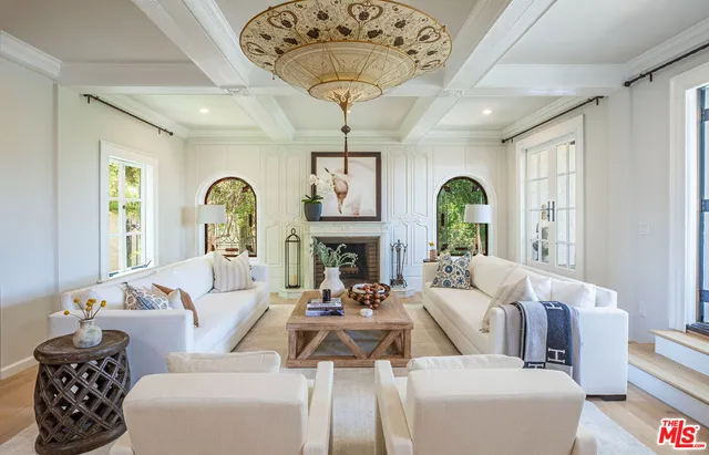 a living room with furniture a chandelier and a large window
