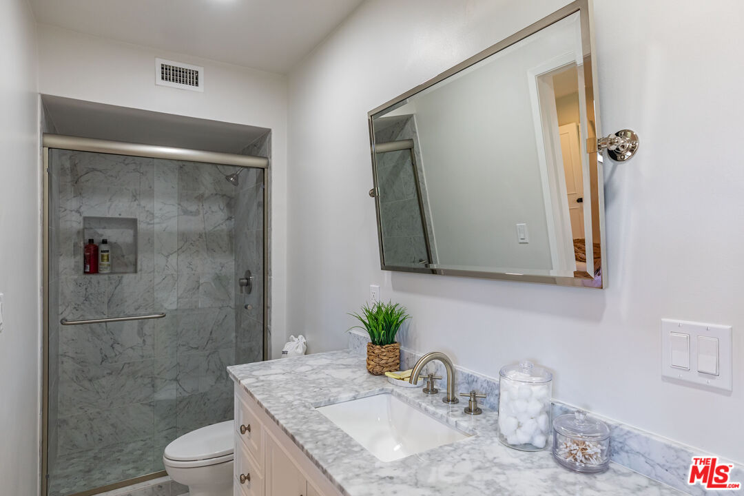 1756 Correa Way Los Angeles, CA 90049 - Photo 34 of 38 a bathroom with a granite countertop sink a toilet and shower