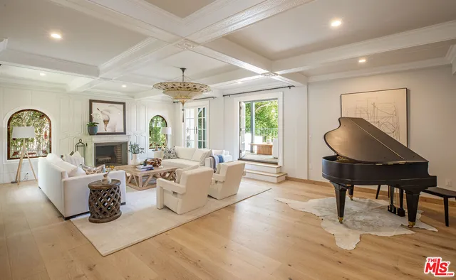 a living room with fireplace furniture and a large window