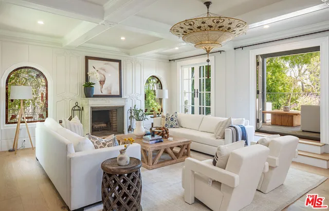 a living room with furniture a fireplace and a large window