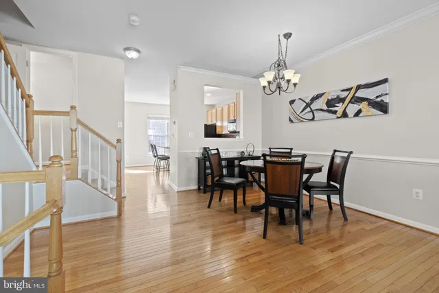 a view of a dining room with furniture a chandelier and wooden floor