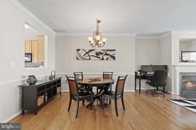 a view of a dining room with furniture a chandelier and wooden floor