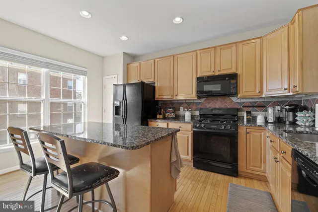a kitchen with kitchen island granite countertop a stove top oven microwave and refrigerator
