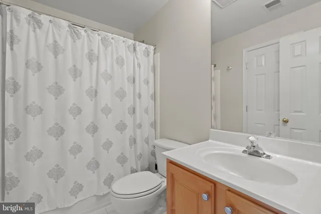 a bathroom with a granite countertop sink a toilet and a mirror