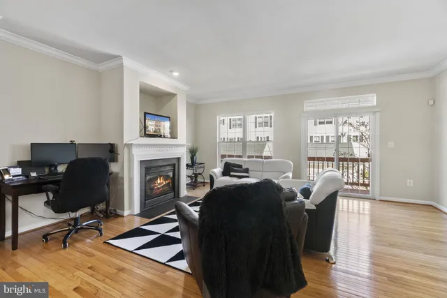 a living room with furniture a fireplace and a floor to ceiling window