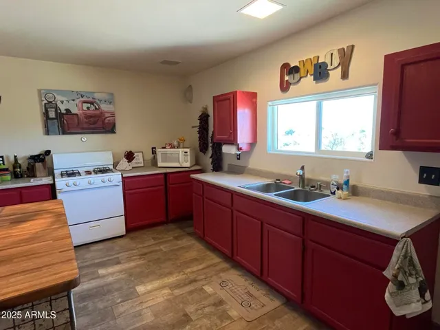 a kitchen with stainless steel appliances sink cabinets and window