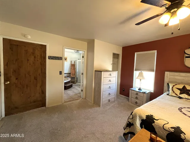 a bedroom with a bed and a large mirror on the dresser