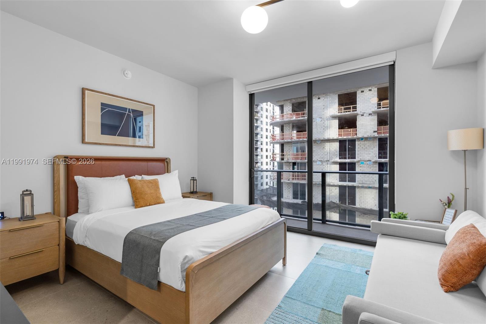 11 Northeast 6th Street, Unit 2808 Miami, FL 33132 - Photo 10 of 57 a spacious bedroom with a bed and a couch
