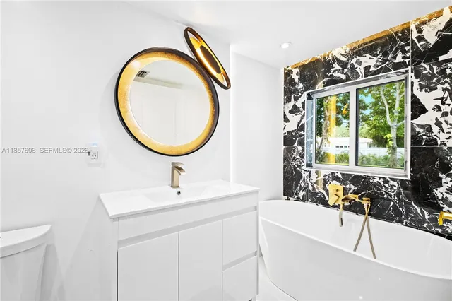 a bathroom with a sink a toilet and a mirror