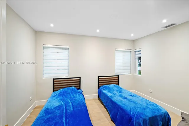 a bedroom with two beds and a window