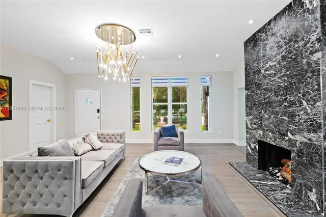 a living room with furniture a fireplace and a chandelier