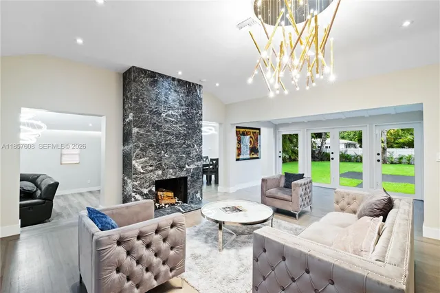 a living room with furniture a fireplace and a chandelier