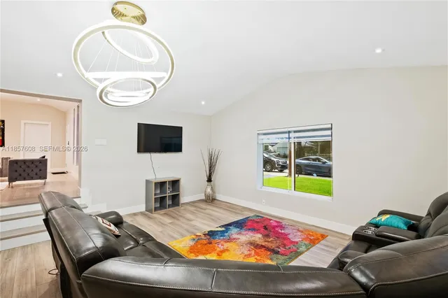a living room with furniture and a chandelier