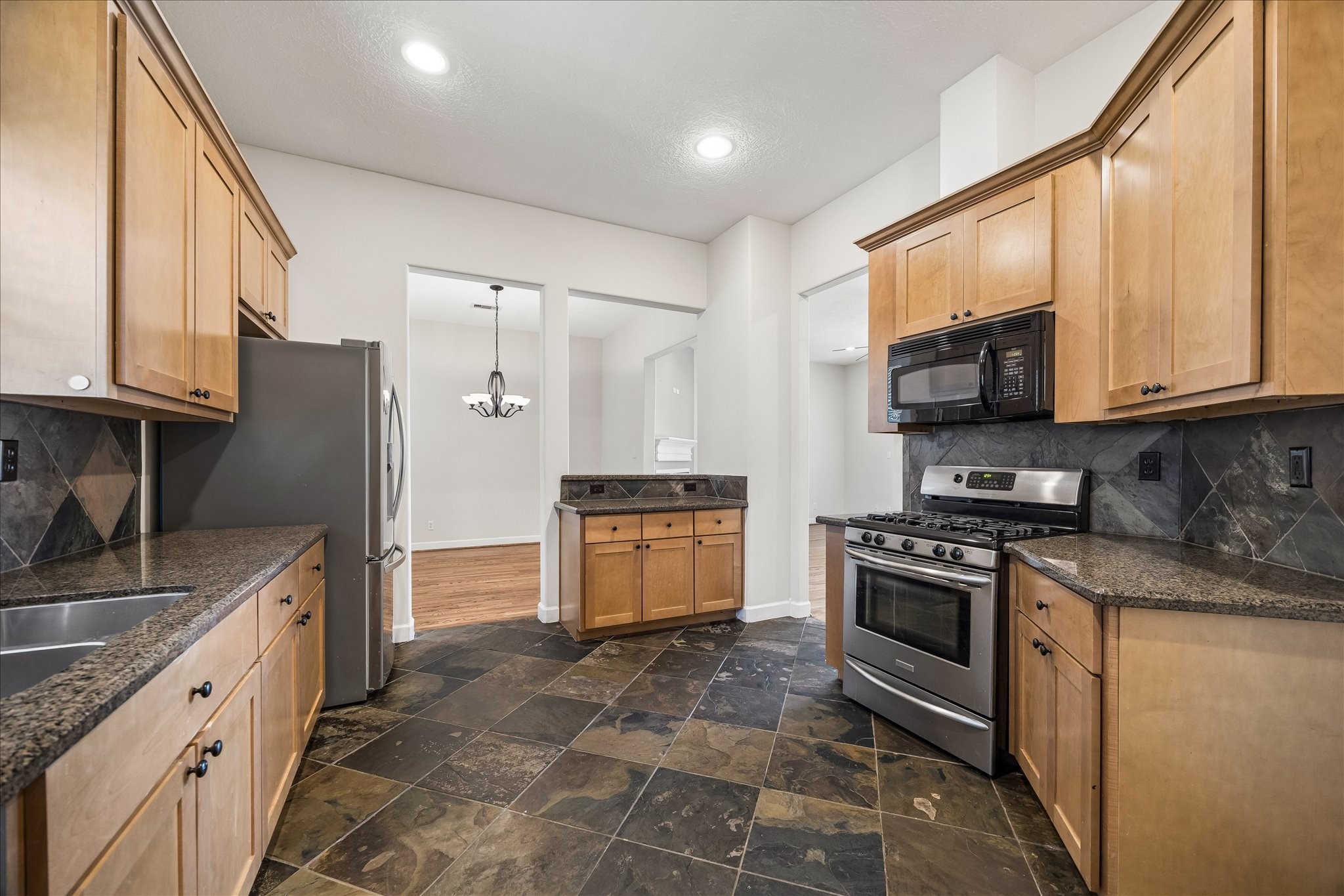5811 Maxie Street Houston, TX 77007 - Photo 19 of 19 a kitchen with stainless steel appliances granite countertop a stove a sink and a microwave