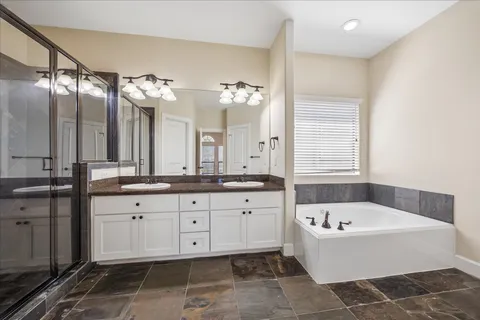 a bathroom with a tub sink and mirror