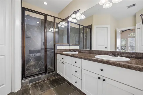 a bathroom with a granite countertop sink mirror and shower