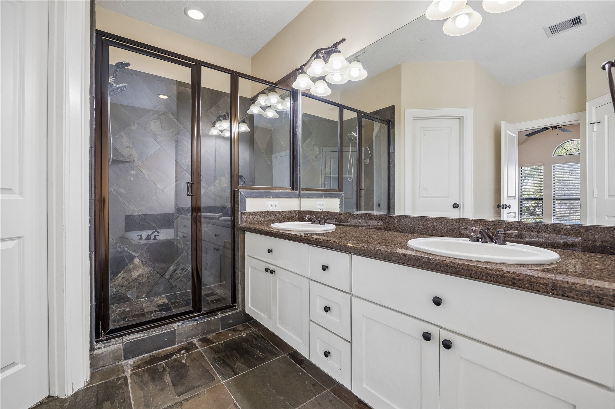 5811 Maxie Street Houston, TX 77007 - Photo 9 of 19 a bathroom with a granite countertop sink mirror and shower