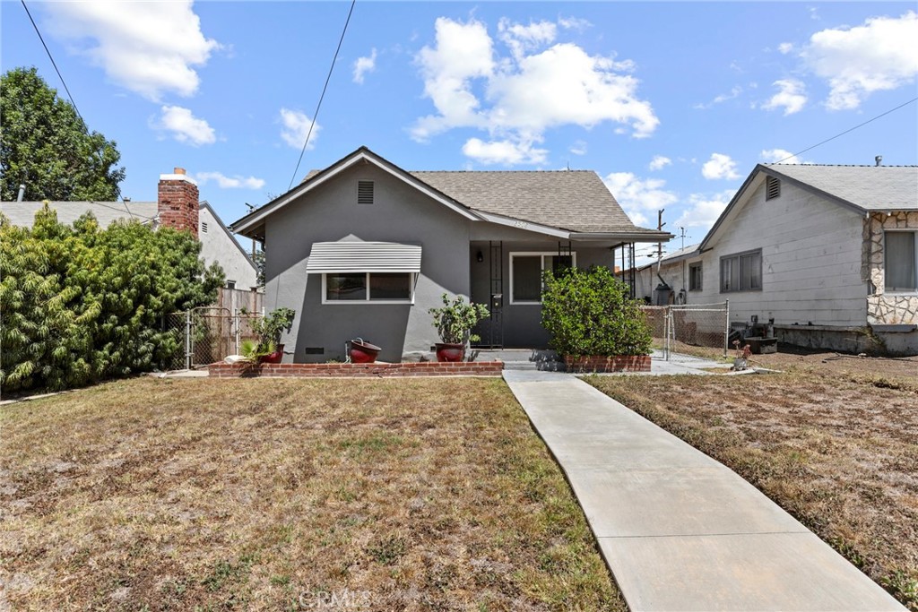 a front view of a house with yard and trees