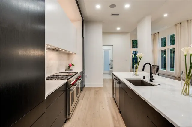 a kitchen with stainless steel appliances a sink stove and cabinets