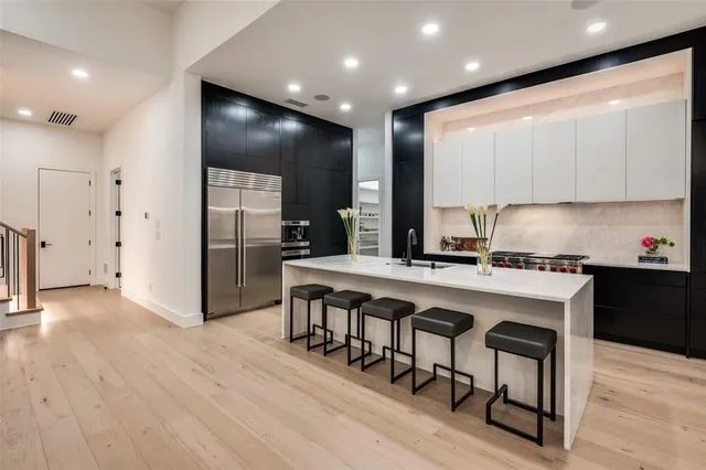 a kitchen with stainless steel appliances granite countertop a refrigerator a sink and a stove