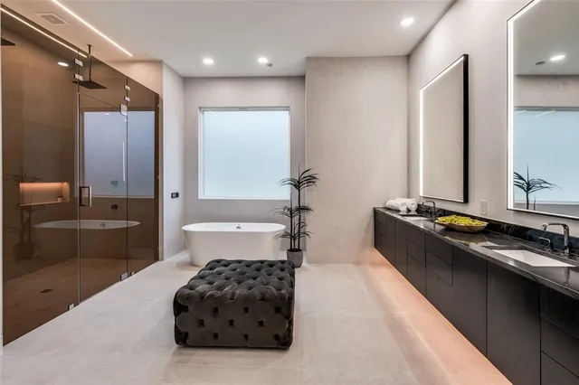 a bathroom with a double vanity sink a mirror and a bathtub