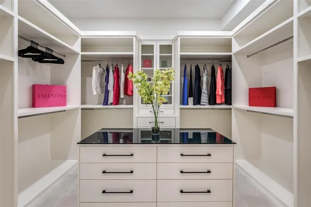 a view of walk in closet with clothes and shoes