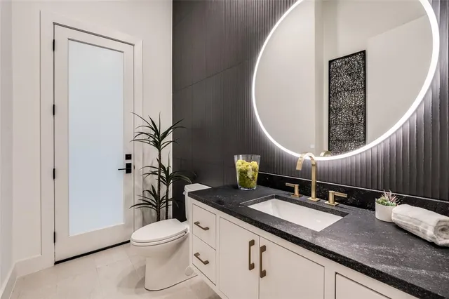 a bathroom with a granite countertop sink a toilet and a mirror