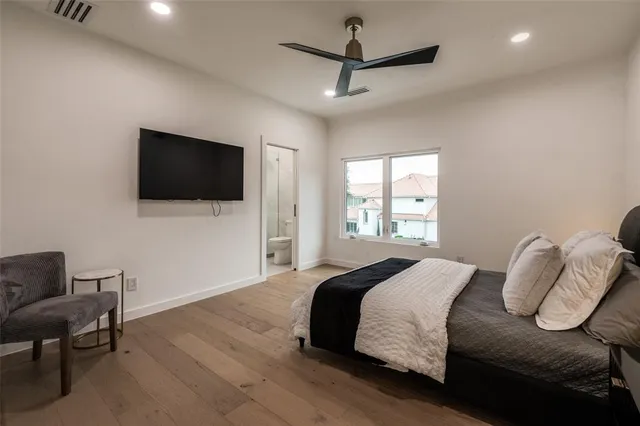 a bedroom with a bed tv and a window