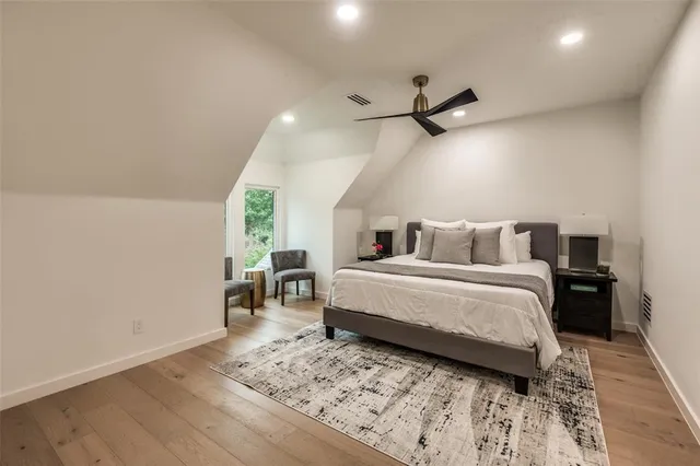 a bedroom with a bed and a table with wooden floor