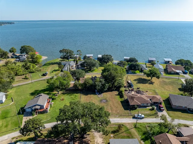 an aerial view of lake and residential houses with outdoor space