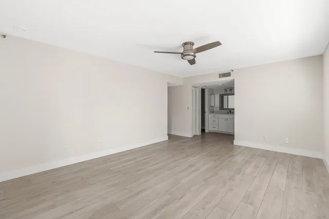 a view of a big room with wooden floor and windows