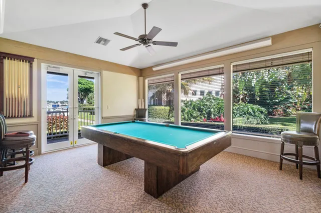a room with pool table and windows
