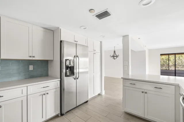 a kitchen with white cabinets and refrigerator