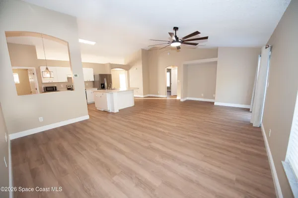a view of a kitchen with wooden floor and a ceiling fan