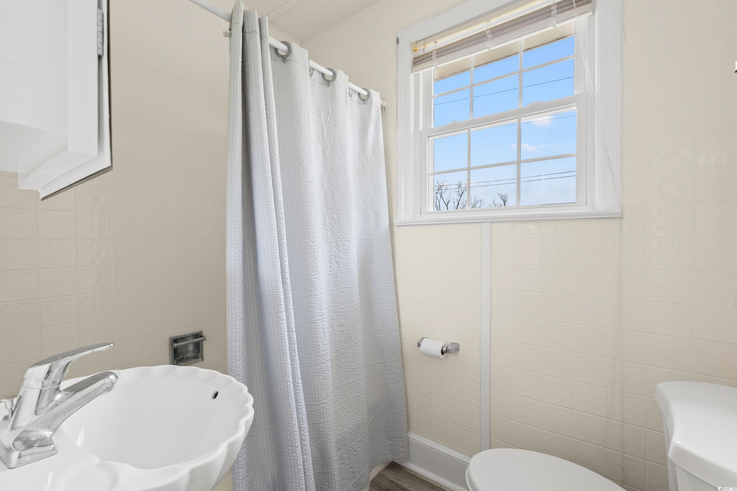 4162 Stevens Street Loris, SC 29569 - Photo 20 of 37 Bathroom featuring a sink, tile walls, toilet, and