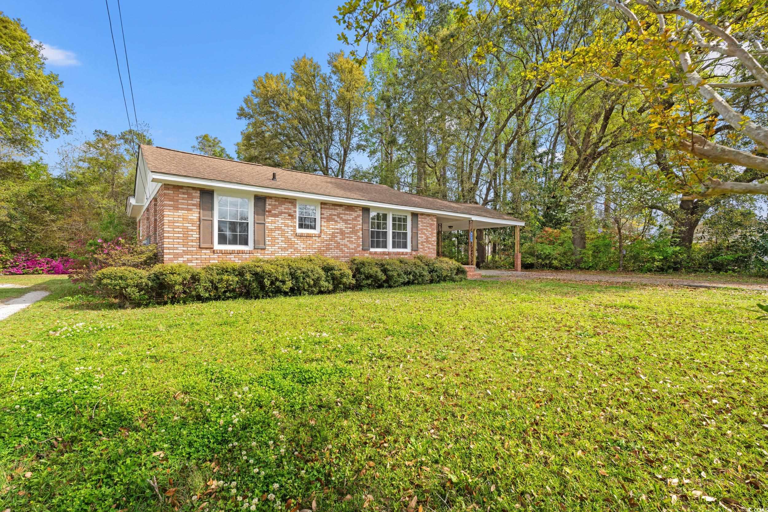 Ranch-style house with a carport, brick siding, an