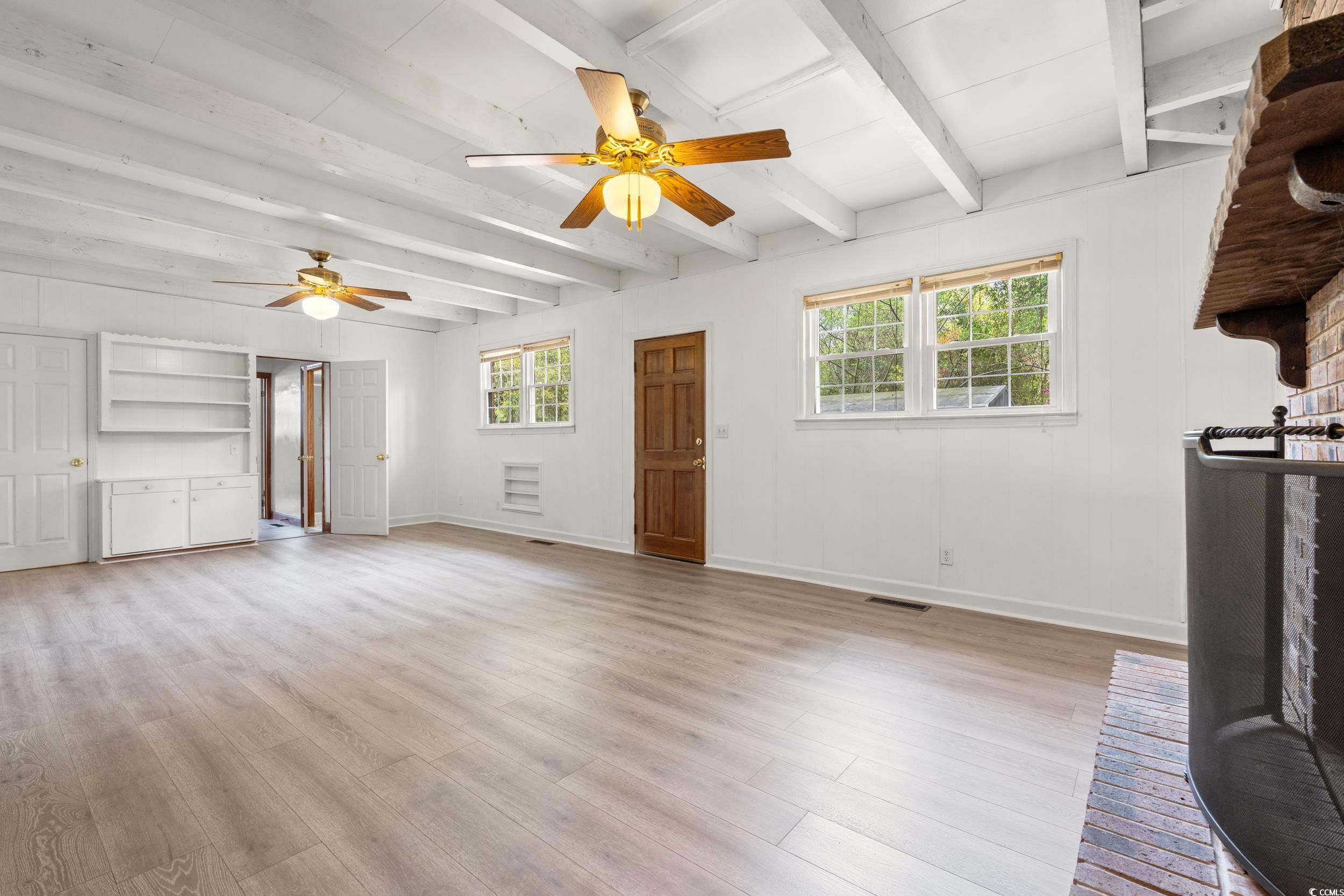 Unfurnished living room with light wood-style floo