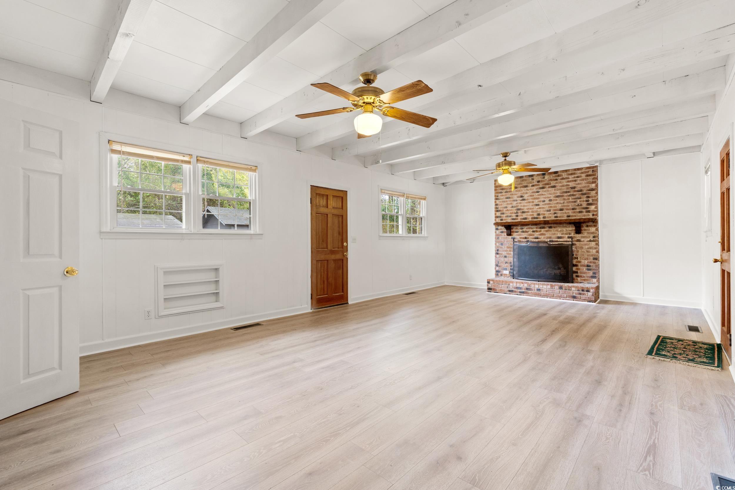 Unfurnished living room with a fireplace, light wo