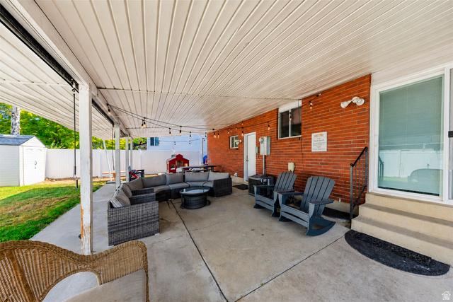 9990 Albury Road Sandy, UT 84092 - Photo 31 of 36 Expansive covered patio featuring a concrete slab, white paneling ceiling, and string lighting