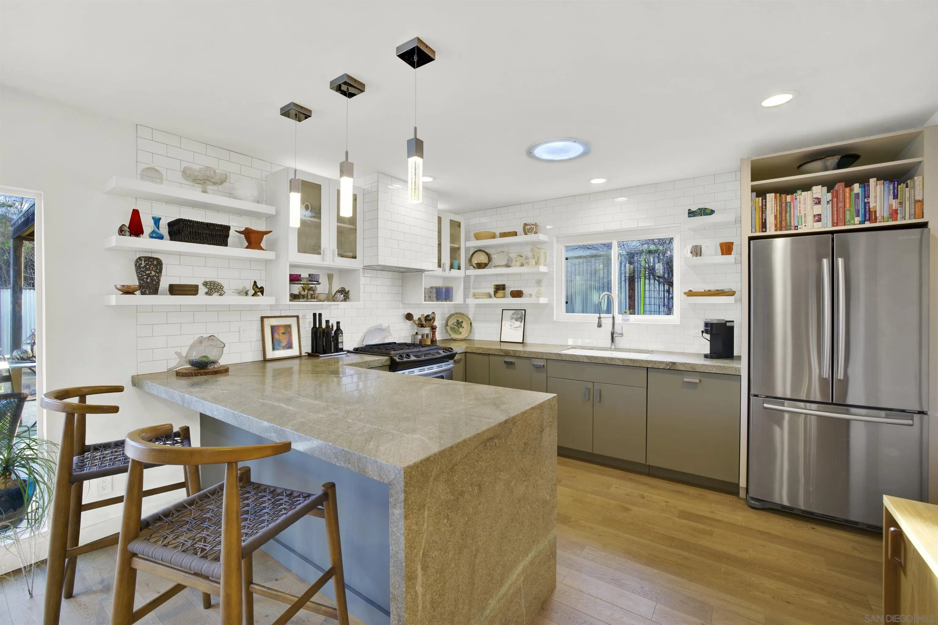 4005 Celeste Drive Oceanside, CA 92056 - Photo 7 of 18 a kitchen with stainless steel appliances granite countertop a refrigerator a stove a sink dishwasher and a dining table with wooden floor