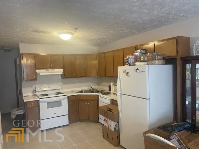 a kitchen with a sink a refrigerator and cabinets