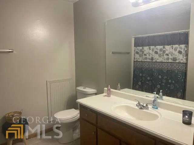 a bathroom with a sink toilet and mirror