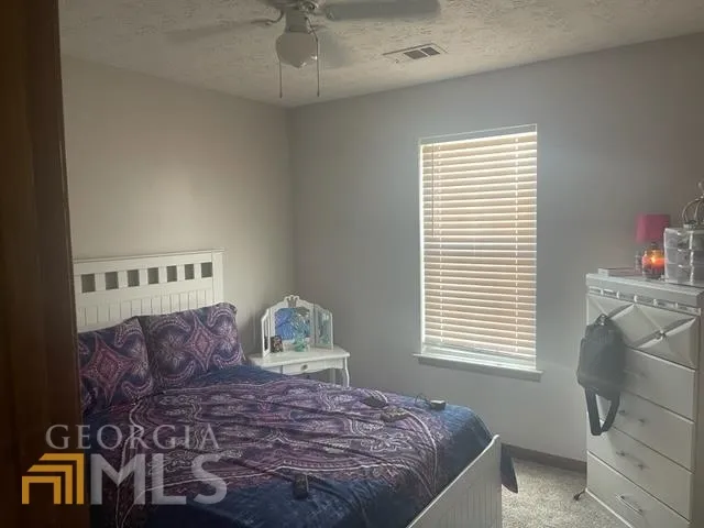a bed sitting in a bedroom next to a window
