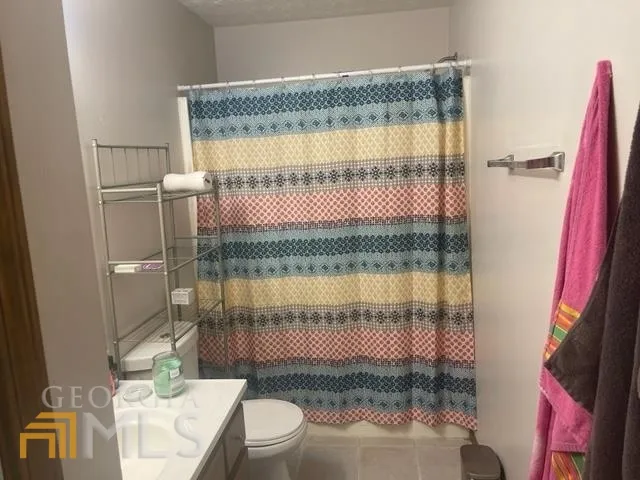 a bathroom with a bathtub sink vanity mirror and toilet