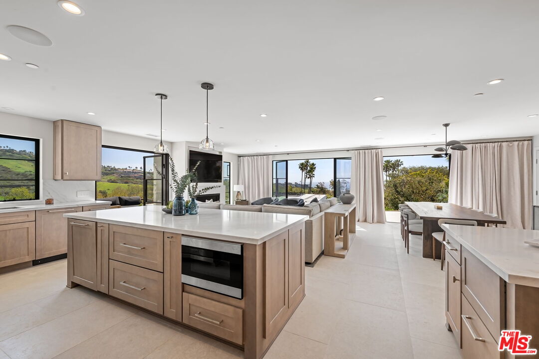 6326 Trancas Canyon Road Malibu, CA 90265 - Photo 15 of 53 a kitchen with stove a sink and chairs