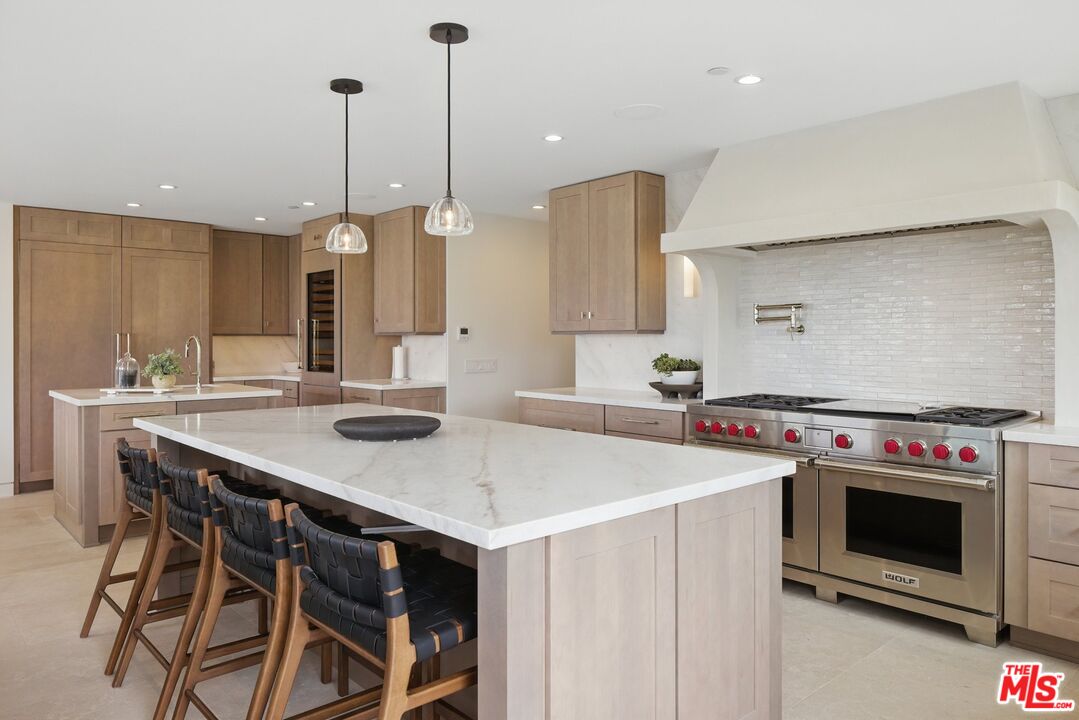 6326 Trancas Canyon Road Malibu, CA 90265 - Photo 20 of 53 a kitchen with stainless steel appliances a stove a sink island and a wooden floor