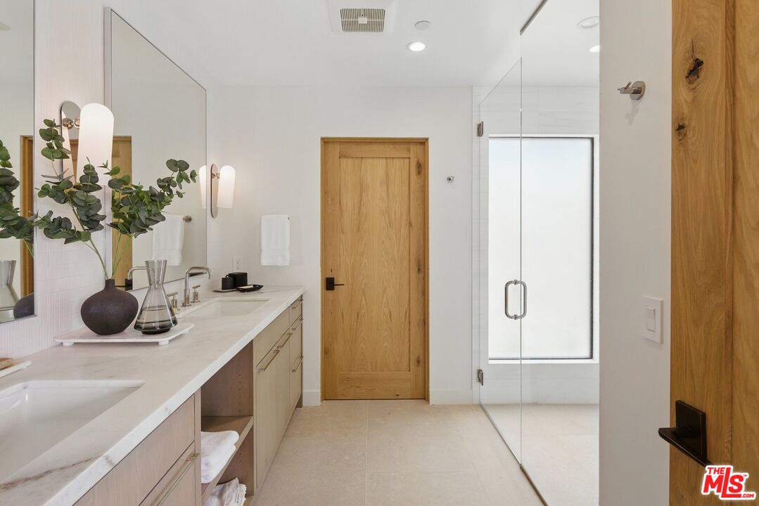 6326 Trancas Canyon Road Malibu, CA 90265 - Photo 27 of 53 a bathroom with a double vanity sink a mirror and shower