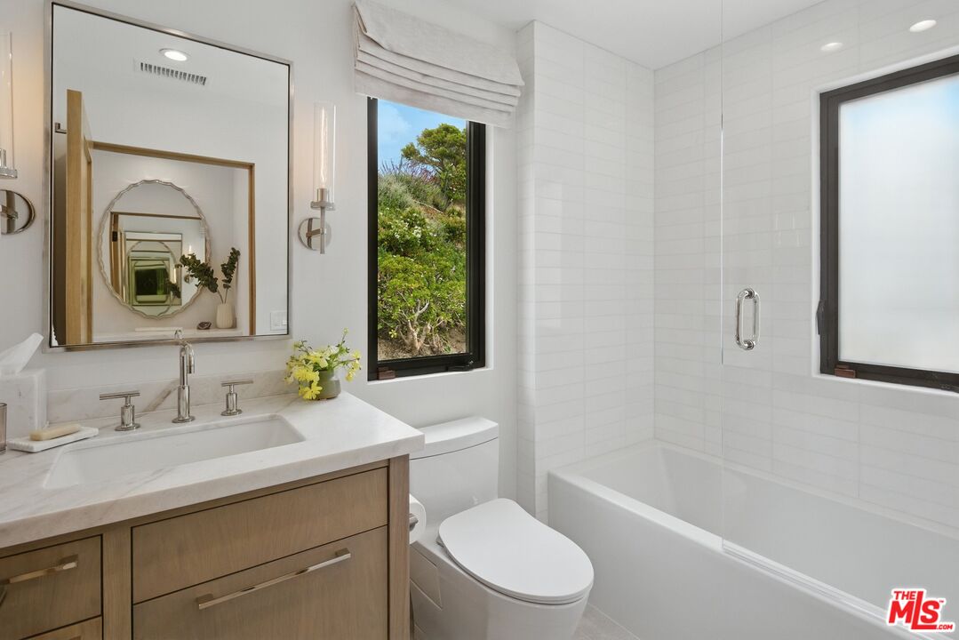 6326 Trancas Canyon Road Malibu, CA 90265 - Photo 33 of 53 a bathroom with a toilet a sink a tub and mirror
