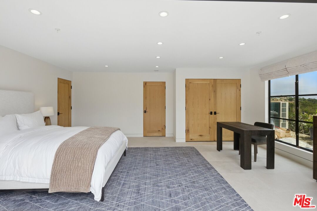 6326 Trancas Canyon Road Malibu, CA 90265 - Photo 43 of 53 a spacious bedroom with a bed and a table in it