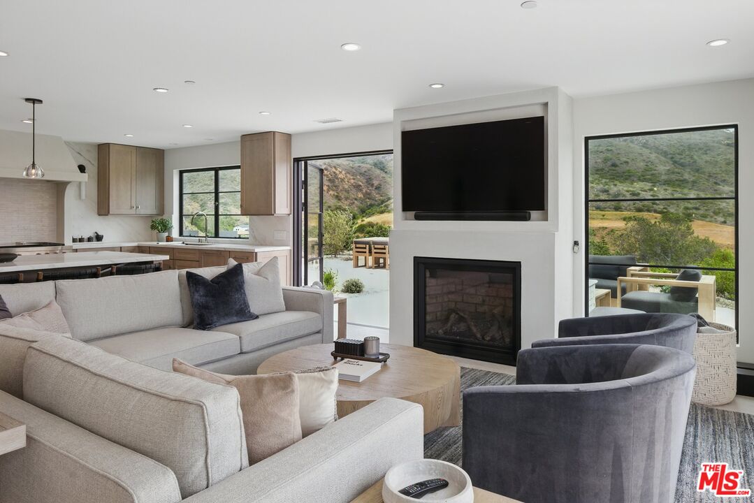 6326 Trancas Canyon Road Malibu, CA 90265 - Photo 5 of 53 a living room with furniture a flat screen tv and a fireplace